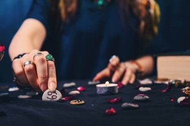 Astroloji ve anlatma. Falcı zodyak taşlarını masaya koyar. Yakın plan. Yıldız falı ve tahminleri kavramı.