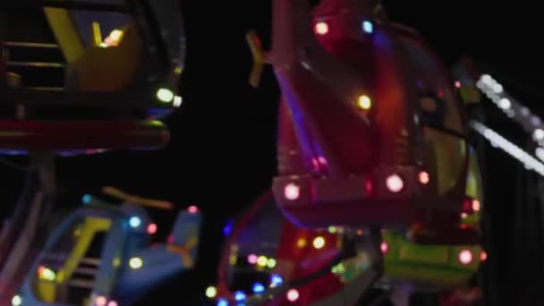 ヘリコプターの形で回転する子供の魅力 ネオンライト 遊園地のナイトライフ — ストック動画