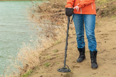 Metal dedektörünün yakına, araştırmacının ayağının seviyesine, nehrin kıyı şeridine..
