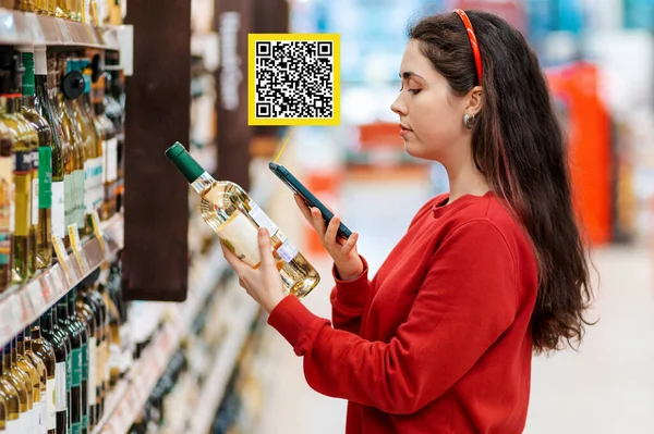 Mladá Běloška Skenuje Kód Láhvi Vína Pomocí Svého Chytrého Telefonu — Stock fotografie