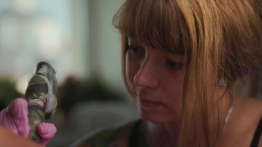 Dövme yaparken gülümseyen bir patates suratlının yakın çekimi. Gerçek zamanlı. Dünya dövme günü.