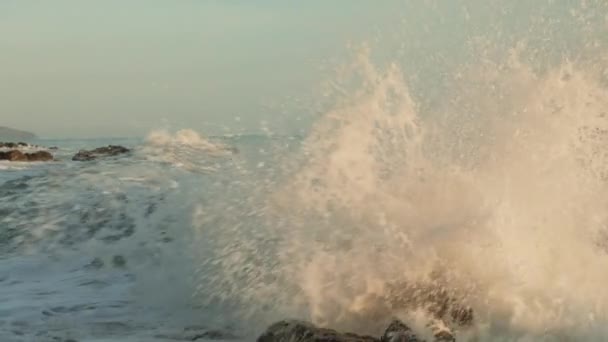 在晴朗的阳光明媚的天气里 可以看到汹涌的大海或大海 巨浪冲击在岩石上 慢动作 — 图库视频影像