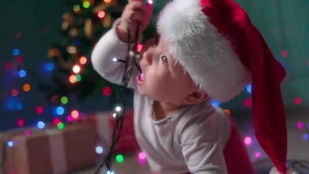 Portrait Funny Happy Baby Christmas Hat Chewing Festive Lights Slow — Stock Video