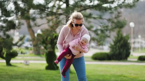 Mother Plays Child Hanging Him Her Arms Outdoors Slow Motion — Stock Video