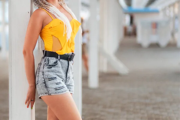 Uma Mulher Esbelta Shorts Top Tanque Amarelo Posa Poste Fechar — Fotografia de Stock