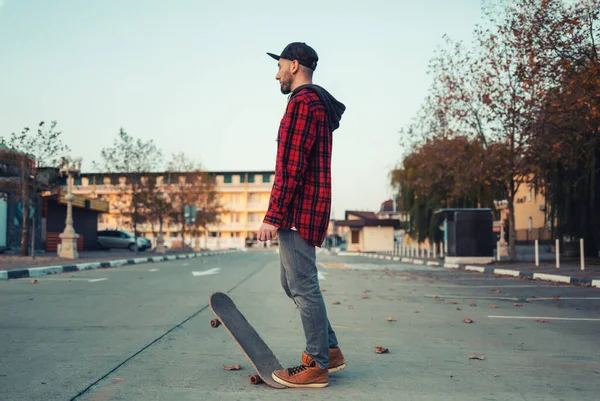 Skateboarding Hombre Posa Con Una Patineta Calle Fondo — Foto de Stock
