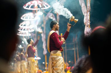 17.12.2019, Varanasi, Hindistan. Tapınakta kutsal dini tören Arati. Bir grup insan tütsü yakıyor. İyi geceler. Açık havada. Yan görünüm.