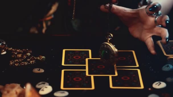 占い師はテーブルの上に広がるタロットカードのお守りを連想させます 濃いマニキュアとリングで手のクローズアップ 分裂と魔法 — ストック動画