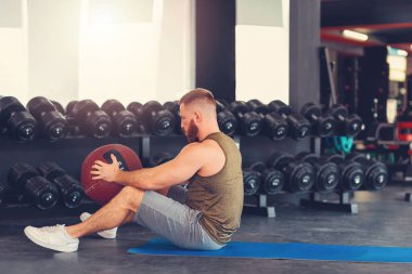 Spor salonunda spor topuyla sakallı sporcu antrenmanı. Yan görüş. Uzayı kopyala Zindelik kavramı.