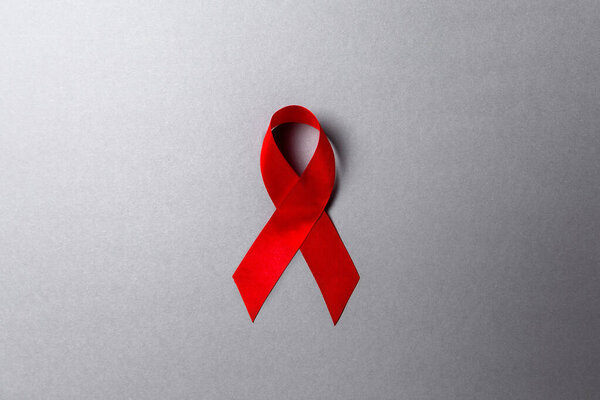 Red ribbon on a gray background. Copy space. Flat lay. The concept of world AIDS day.