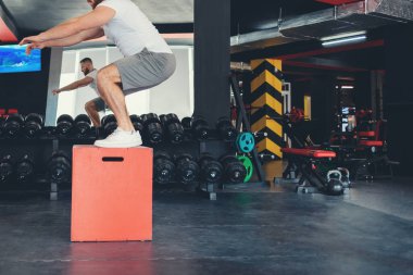 Spor salonunda Küp 'te atlama antrenmanı. Uzayı kopyala Çapraz eğitime ayak uyduruyorum. Zindelik kavramı.