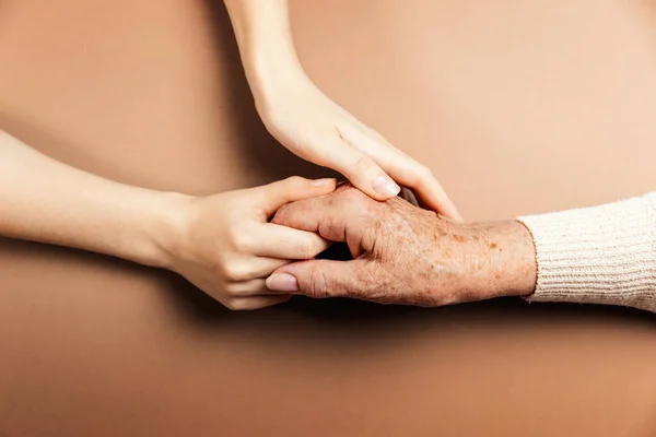Mãos Uma Jovem Mulher Seguram Mão Enrugada Uma Avó Idosa — Fotografia de Stock
