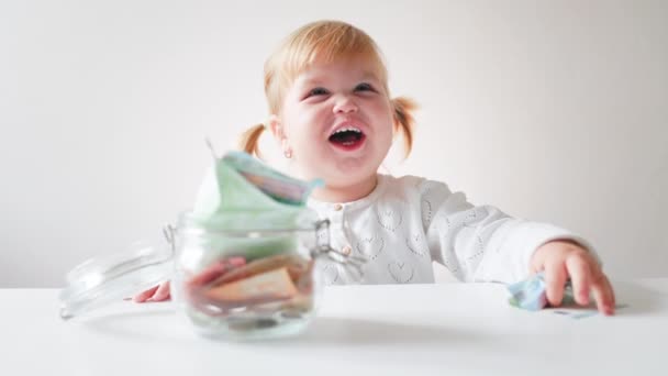 Una Niña Divertida Toma Euros Frasco Vidrio Estornuda Ríe Cámara — Vídeos de Stock