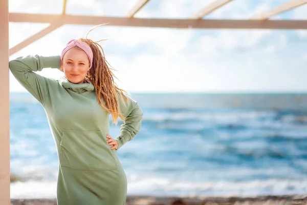 海と空に向かってポーズをとっているドレッドロックを持つ若い笑顔の女性 コピースペース 心理学の概念 — ストック写真