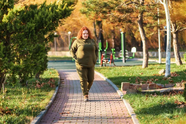 公園ではぽっちゃりとした広々とした女がひとりで歩いている コピースペース 心理学と孤独の概念 — ストック写真