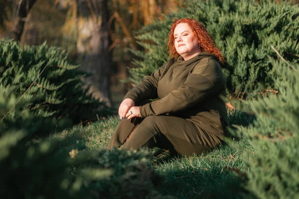 太陽の下で 公園の芝生の上に座っている太りすぎの美しい女性が温暖化している 心理学と平和の概念 — ストック写真