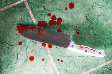 Yerde kanlı büyük, keskin bir mutfak bıçağı var. Kapatın. Suç ve cinayet kavramı.