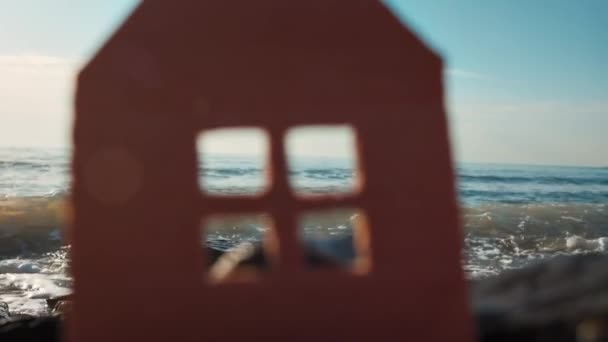 Ein Aus Pappe Geschnittenes Haus Auf Dem Hintergrund Des Strandes — Stockvideo