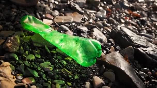 一位志愿者把一个塑料绿色瓶子放进垃圾袋 戴防护手套的手的特写 清理海洋的概念 — 图库视频影像