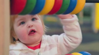 Close up portrait of cute little girl is playing educational games on the playground. Slow motion. The concept of child development and autism