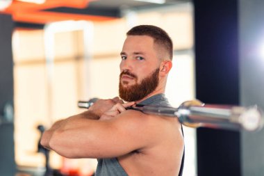 Portrait of a bearded man holding a barbell. Sports concept.