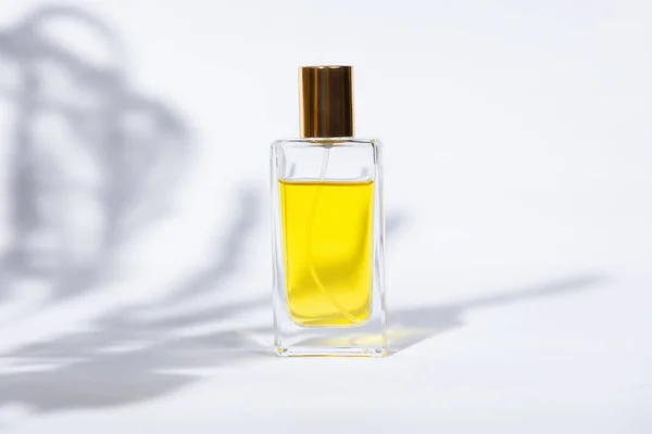 Transparent Rectangular Bottle Golden Perfume White Background Sunlight Shadows Leaves — Stock Photo, Image