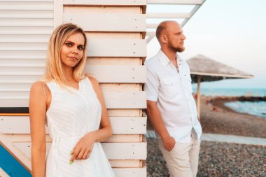 Valentines day. A young beautiful woman is hiding behind a wall from her lover, waiting for her on a date. Romantic relationship.