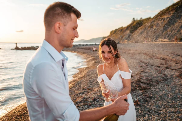 Wedding Day Husband Wife Cheerfully Open Bottle Champagne Ocean Background — Zdjęcie stockowe