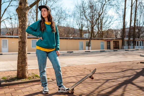 Young Caucasian Hipster Woman Poses Her Foot Skateboard Looks Distance — Stockfoto