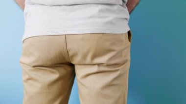 Kot pantolonlu bir adam arkasını döner fermuarını çeker ve elinde analiz için bir kavanozda sperm örneği tutar. Kapatın. Sperm bağışı ve yapay döllenme kavramı.