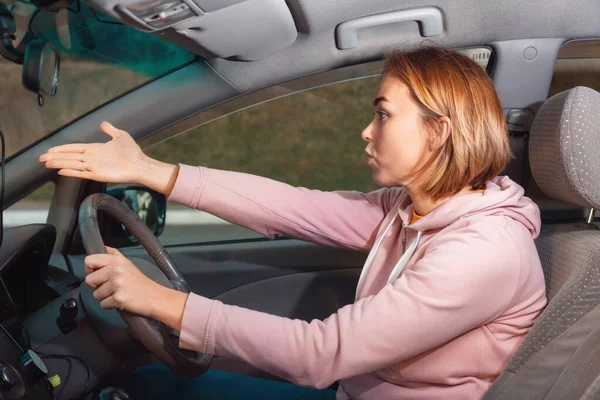 一个年轻紧张的女人坐在一辆右手汽车的轮子后面咒骂着 用她的手指指着路 道路上的交通堵塞及交通意外概念 — 图库照片