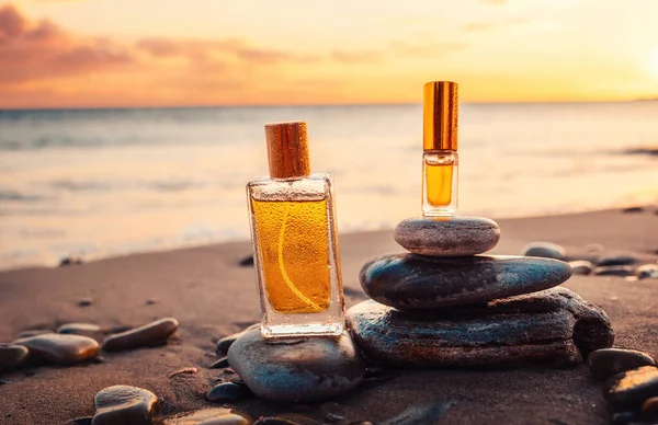 Kumlu Bir Sahilde Iki Altın Cam Parfüm Şişesi Yakın Plan — Stok fotoğraf