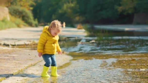 Legrační Holčička Žlutých Gumových Botách Opatrně Vstoupí Řeky Hraje Vodou — Stock video