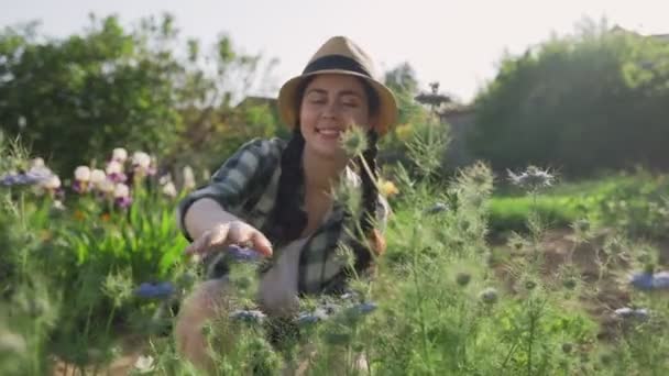 Uma Jovem Mulher Feliz Sentada Perto Dos Arbustos Azuis Nigella — Vídeo de Stock