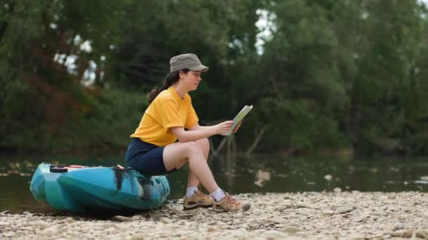 Una Joven Está Sentada Kayak Sosteniendo Mapa Papel Revisando Ruta — Vídeo de stock