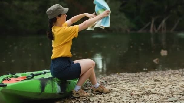 Seorang Wanita Muda Duduk Atas Kayak Memutar Peta Kertas Arah — Stok Video