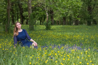 Parkta oturmuş mavi elbiseli güzel bir kız..