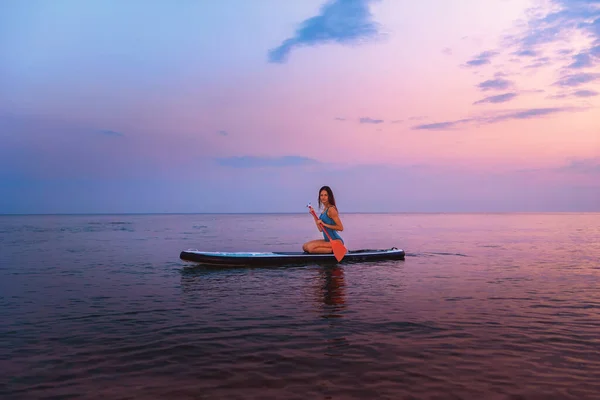 Una Joven Mujer Sonriente Posa Sentada Una Tabla Sup Con —  Fotos de Stock