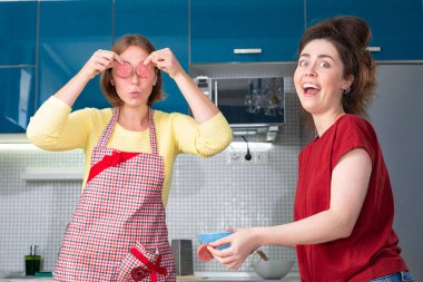 İki beyaz kadının portresi mutfakta yemek pişiriyor ve birlikte eğleniyorlar. İçeride. LGBT çiftleri için ev yemeği kavramı.