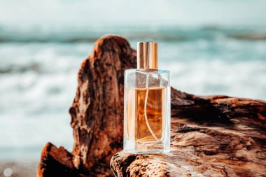 Erkekler tuvalet suyu. Dalgaların üzerinde duran dikdörtgen cam bir parfüm şişesi. Arka planda okyanus dalgaları var. Parfüm konsepti ve reklam şablonu.