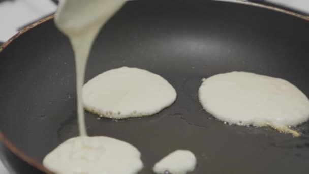 熱い油で古いフライパンにスプーンで生地を注ぐ人 接近中だ 朝食に自家製パンケーキを作る — ストック動画