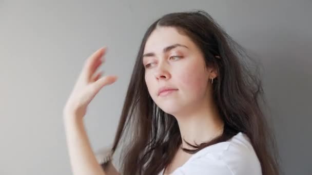 Портрет Молодой Белой Женщины Расчесывающей Запутавшиеся Волосы Расчёской Серый Фон — стоковое видео