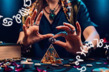 Astroloji ve yıldız falı. Bir cadı zodyak arması olan bir taş tutuyor. Kapatın. Zodiac çemberleri