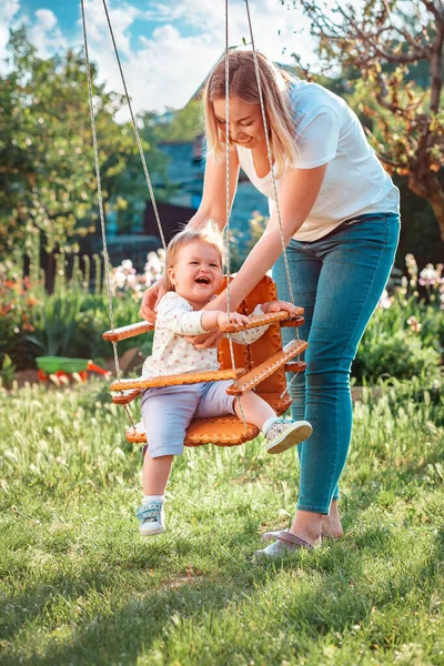 어린이의 International Childrens Day 개념이다 어머니는 그네를 다닌다 뒷마당의 운동장에서 — 스톡 사진