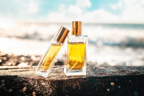 Dos Botellas Vidrio Perfume Dorado Una Piedra Mojada Oleaje Marino — Foto de Stock