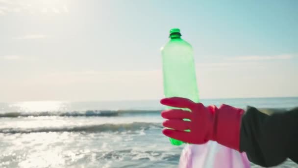 Volunteer Protective Gloves Holds Plastic Bottle Puts Garbage Bag Ocean — Stock Video