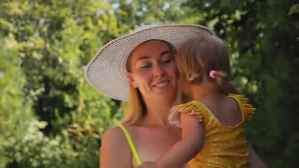 Young Smiling Mother Straw Hat Swimsuit Holds Small Crying Child — Stock Video