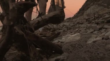 Çevre koruma. Lastik eldivenli bir işçi kirli plastik bir şişeyi çantaya koyar ve çeker gider. Bacaklar yakın plan. Dünya Günü konsepti.