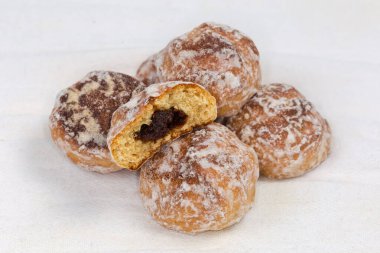 Beyaz kumaş peçeteye krema kaplı reçelli yuvarlak baharatlı kurabiyeler, seçici odak noktasında yakın plan.