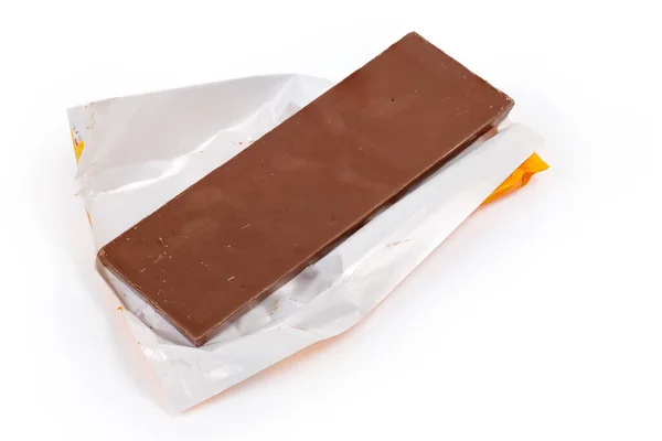 牛奶巧克力的一大块放在一个开了的部分皱折的纸包装纸上 包装纸的背景是白色的 — 图库照片